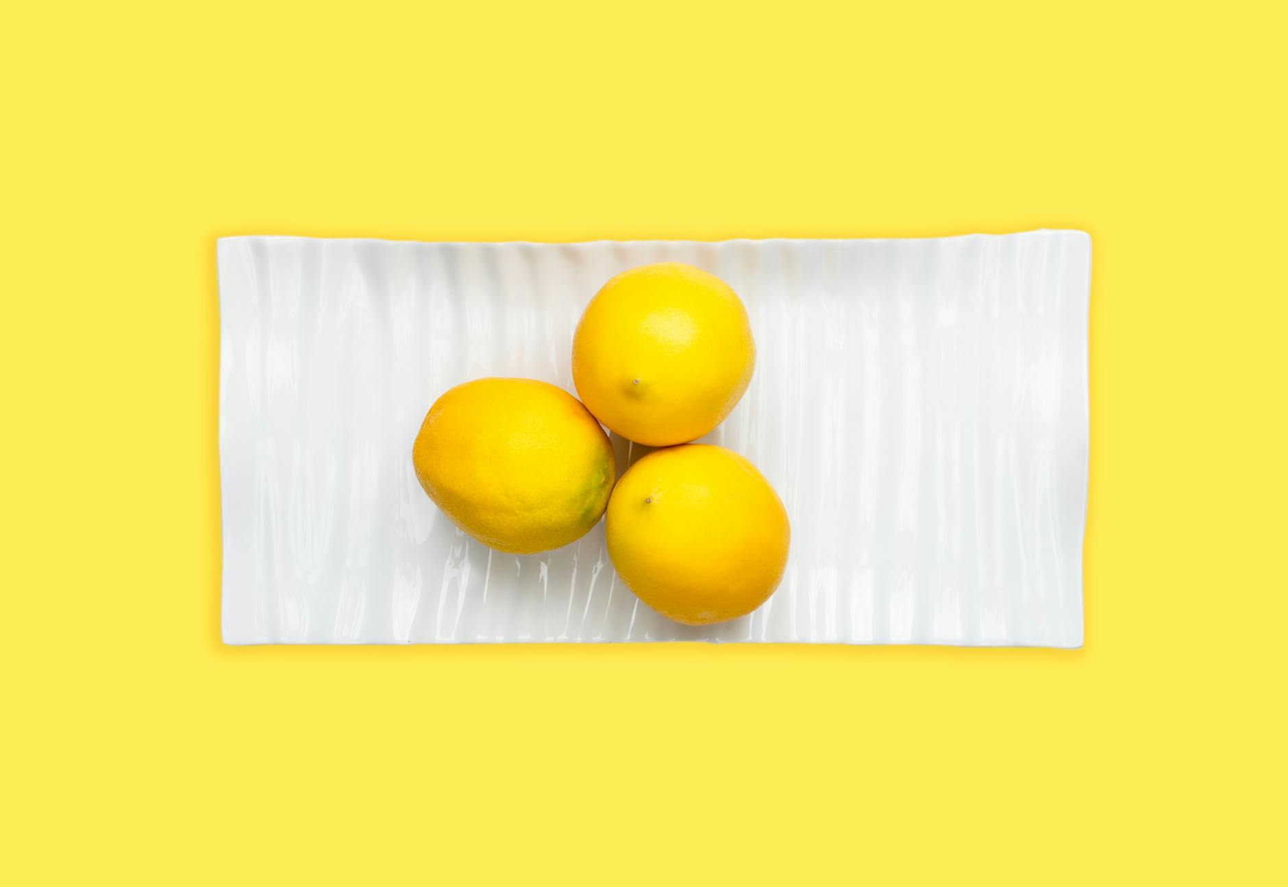 Due limoni freschi tra le mani su una superficie marrone, simbolo di freschezza e intimità condivisa