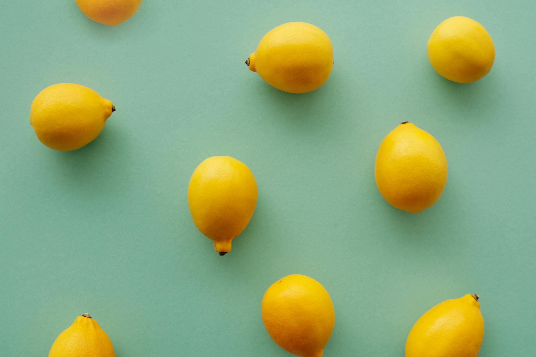 Bright yellow lemons arranged on a pastel background, symbolizing fresh, unapologetic pleasure and joy