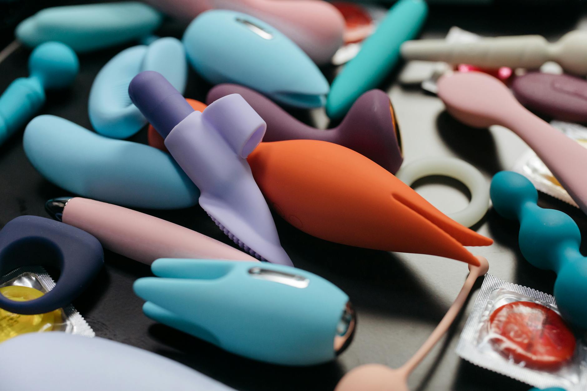 Mani che tengono un vibratore blu elegante su sfondo viola, simbolo di intimità consapevole