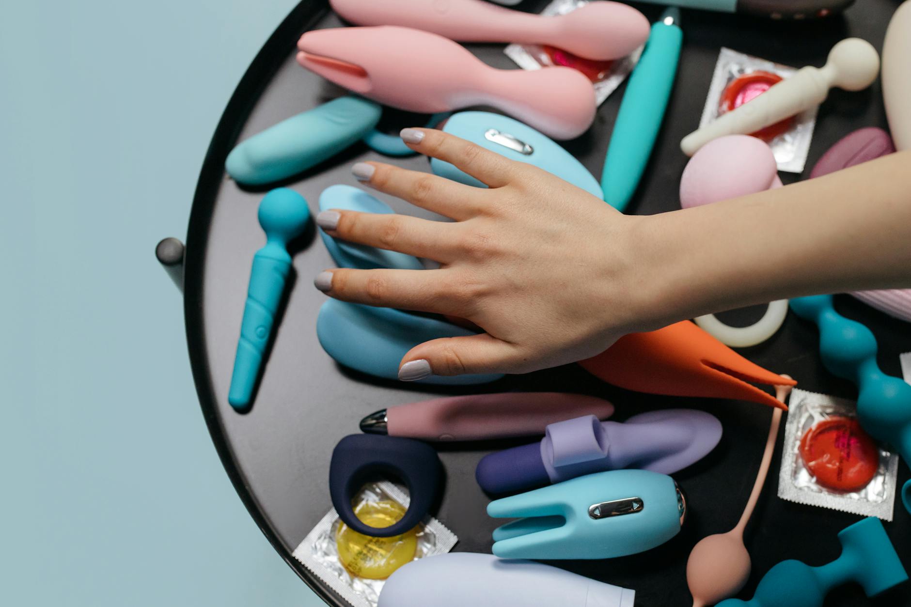 Donna che tiene in mano un vibratore mentre riflette sulla propria sensibilità dopo il parto