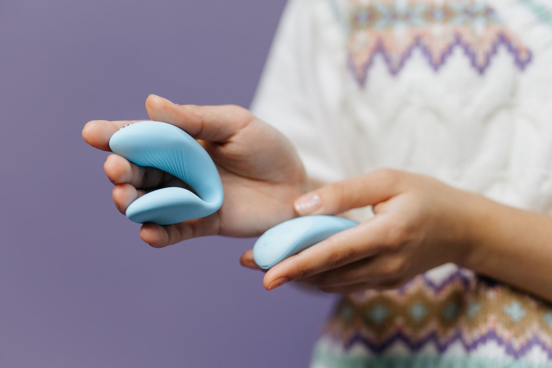 Una giovane coppia insieme in intimità, che tiene un vibratore blu, simbolo della moderna intimità di coppia.