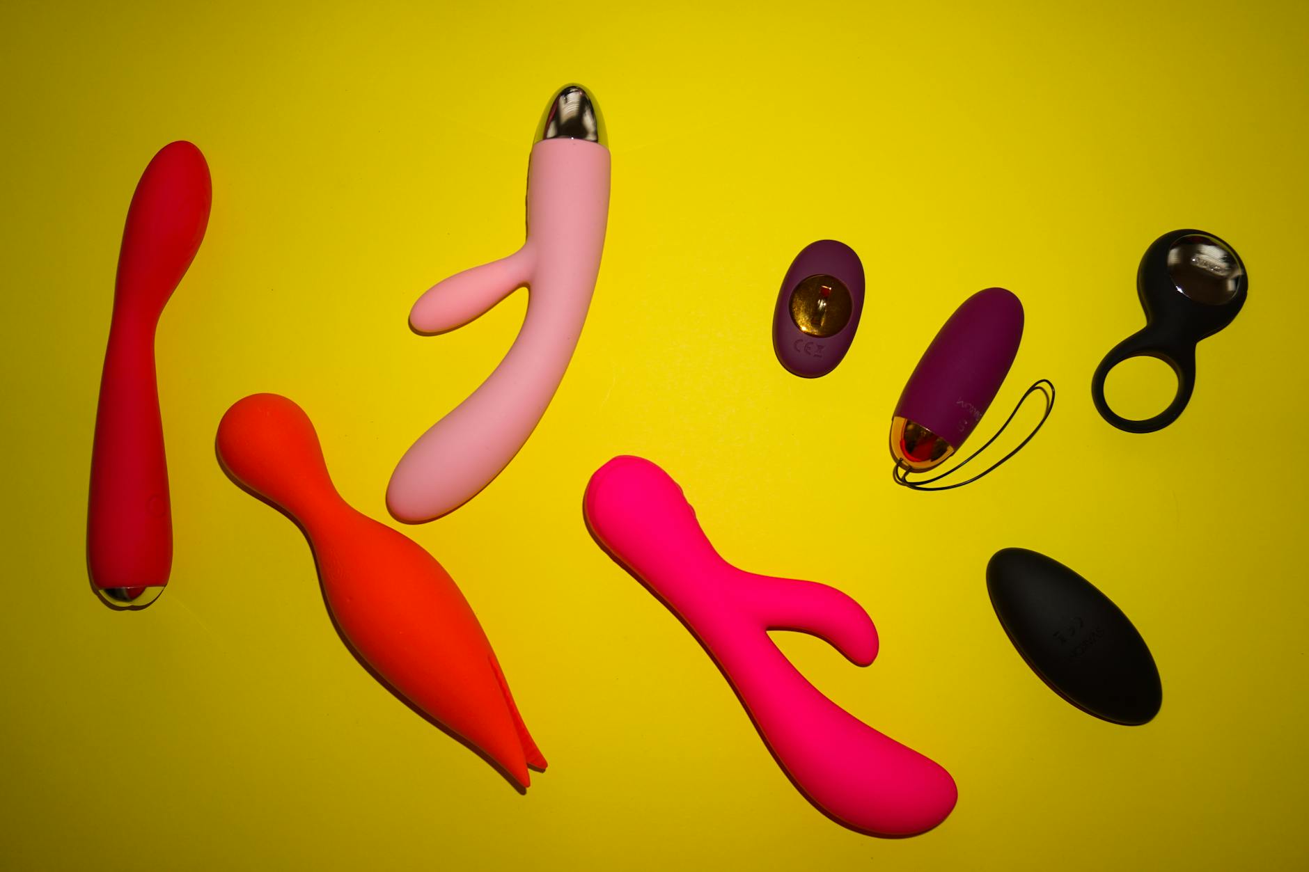 Mani che tengono un vibrator clitorideo blu contro uno sfondo viola in una foto intima