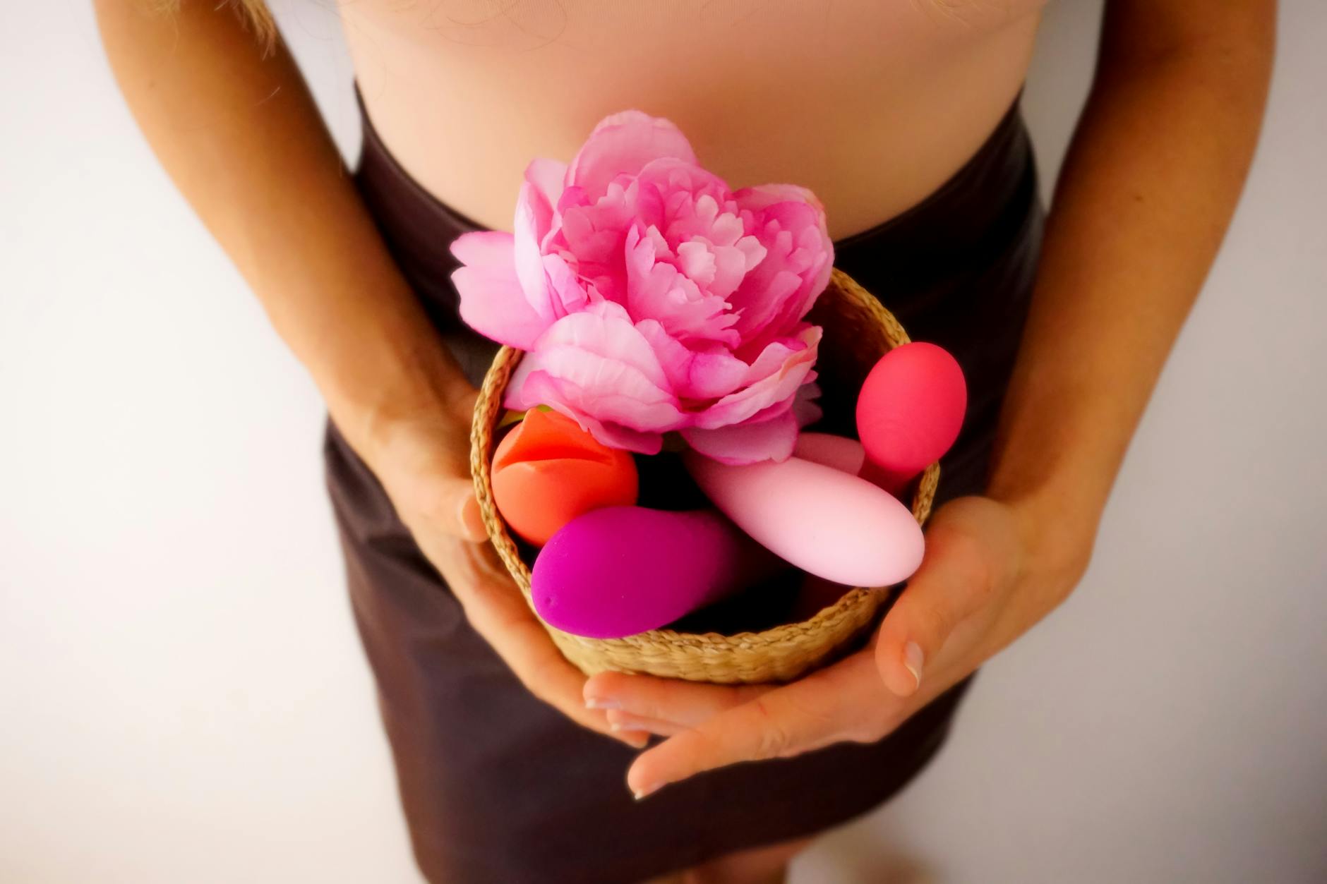 Woman holding a colorful vibrator toy while relaxing at home